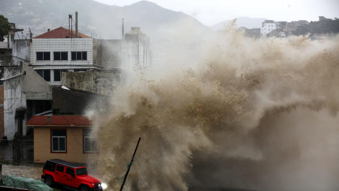A strong wave breaks over a vehicle along the shore ahead of the landfall of Typhoon Chan-Hom in Wenling in eastern China&#39;s Zhejiang province Friday July 10, 2015. Chinese authorities have evacuated tens of thousands of people, canceled scores of trains and flights and shuttered seaside resorts as a super-typhoon with wind gusts up to 200 kilometers per hour (125 mph) heads toward the southeastern coast.(Chinatopix Via AP) CHINA OUT