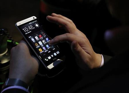 An attendee tests the new HTC One during a launch event in New York, February 19, 2013. REUTERS/Brendan McDermid