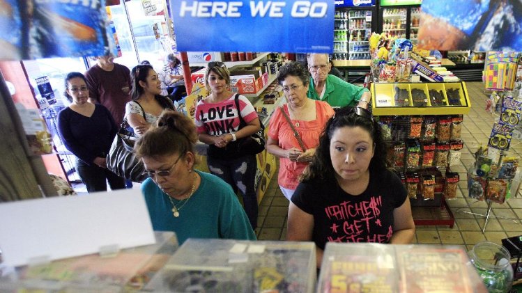 ople stand in line as they prepare to buy lottery 