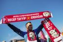 A street vendor sells scarves with a picture of Turkish President Recep Tayyip Erdogan, as supporters wait for Prime Minister Ahmet Davutoglu at the Istanbul Ataturk airport on November 3, 2015