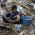A resident rummages through debris following a flash flood that inundated Cagayan de Oro city, Philippines, Saturday, Dec. 17, 2011. A tropical storm triggered flash floods in the southern Philippines, killing scores of people and missing more. Mayor Lawrence Cruz of nearby Iligan said the coast guard and other rescuers were scouring the waters off his coastal city for survivors or bodies that may have been swept to the sea by a swollen river. (AP Photo/Froilan Gallardo)