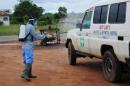 A health worker sprays disinfectant on an ambulance in Nedowein