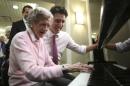 Liberal leader Trudeau watches a woman play the piano while touring a retirement home in Mississauga