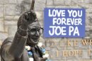 Signs and flowers are seen at the statue of the late Penn State football coach Paterno in State College