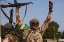 Chadian soldiers wave their guns as they drive in Bangui