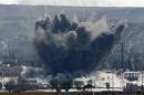 An explosion following an air-strike is seen in the Syrian town of Kobani during heavy fighting