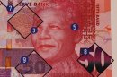 A poster showing safety features of a bank note bearing the image of former president Nelson Mandela, at a press launch, in Pretoria, South Africa, Tuesday, Nov. 6, 2012. New South African banknotes featuring the image of former president and anti-apartheid icon Nelson Mandela are going into circulation. Reserve bank governor Gill Marcus made the first purchase using the new rand notes at a small shop in Pretoria Tuesday. She says the country tries to upgrade its notes every seven years for security reasons as technologies change. (AP Photo/Denis Farrell)