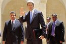 U.S. Secretary of State John Kerry waves to members of the media before meeting with Jordan's King Abdullah in Amman