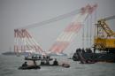Boats and cranes surround the site of the submerged 'Sewol' ferry off the coast of Jindo on April 21, 2014
