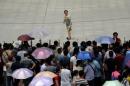 A teacher looks back at family members waiting outside a high school during the national college entrance exam in Wuhan, Hubei province