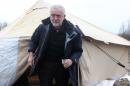 Britain's Labour Party leader Jeremy Corbyn leaves a tent during a visit at the camp of migrants in Calais, northern France, Saturday, Jan. 23, 2016. Corbyn tours in Dunkirk and Calais in northern France to meet various volunteer groups and refugees to focus on unaccompanied children. (AP Photo/Michel Spingler)