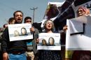 Yemenis hold posters showing kidnapped Frenchwoman Isabelle Prime (R) and her Yemeni interpreter Sherine Makkaoui during a demonstration in solidarity with them, on March 5, 2015 in the capital Sanaa