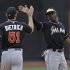 Miami Marlins shortstop Adeiny Hechavarria, right, celebrates the Marlins 8-4 victory over the New York Mets with Miami Marlins second baseman Derek Dietrich (51) at the conclusion of their baseball game in New York, Sunday, June 9, 2013. (AP Photo/Kathy Willens)