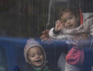 Young kids look out of a train window after they arrive&nbsp;&hellip;