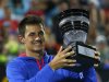 Tomic of Australia poses with the trophy after defeating Anderson of South Africa during their men's final match at the Sydney International tennis tournament