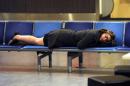 A woman sleeps at Gatwick Airport in southern England on December 7, 2013