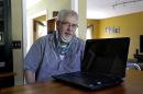 This photo taken May 8, 2014 shows Mark Matulaitis posing with his laptop that he uses for virtual house calls with his neurologist in his home in Salisbury, Md. Matulaitis has had Parkinson's disease since 2011 and sees a neurologist at the University of Rochester via his laptop and special Skype-like software. (AP Photo/Patrick Semansky)