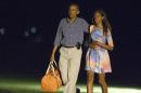 President Barack Obama walks with his daughter Malia as he arrives on the South Lawn of the White House on Monday, Aug. 18, 2014, in Washington. Obama is taking a break in the middle of his Martha's Vineyard vacation to return to Washington for meetings with Vice President Joe Biden and other advisers on the U.S. military campaign in Iraq and tensions between police and protesters in Ferguson, Missouri. (AP Photo/Evan Vucci)