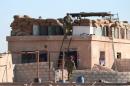 A U.S. fighter walks down a ladder from a barricade, north of Raqqa