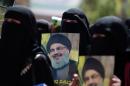 Yemeni students hold posters bearing portraits of Lebanon's Hezbollah chief Hassan Nasrallah during a rally on March 8, 2016 in Sanaa