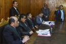 In this Wednesday, Feb. 4, 2015 photo, Egyptian Judge Mohammed Nagi Shehata, third left, presides over a court hearing in a case against 230 people including Ahmed Douma, one of the leading activists behind the country's 2011 uprising, in a courtroom of Torah prison, Cairo, Egypt. If you're branded an enemy of the state in Egypt, you may never get the chance to defend yourself in a justice system racking up convictions in lop-sided mass trials according to legal observers and human rights groups. President Abdel-Fattah el-Sissi is unrepentant, arguing his government must enforce stability at the expense of human rights in a country where many thousands face prosecution after years of unrest. (AP Photo/Mohammed El-Raaei)