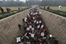 Women carrying placards enter Raj Ghat to attend a prayer ceremony for a rape victim after a rally protesting for justice and security for women, in New Delhi