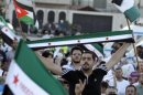 Syrian residents in Jordan hold pre-baath national flags, which were adopted by the opposition