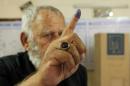 An Iraqi man shows his ink-stained finger after casting his vote in landmark elections at a polling station in Baghdad on April 30, 2014
