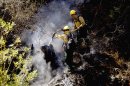 Firefighters work on extinguishing a fire in the Los Padres National Forrest near Santa Barbara, Calif. on Tuesday, May 28, 2013. Firefighters took advantage of a lull in winds on Tuesday to try to gain ground against a forest fire in mountains north of Santa Barbara, as crews elsewhere in Southern California chased a new fire north of Los Angeles and sought to increase containment of a rural San Diego County blaze. (AP Photo/Nick Ut)
