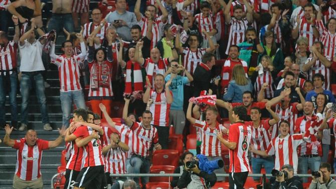 Athletic Bilbao&#39;s forward Aritz Aduriz (L) is congratulated by teammates after scoring their team&#39;s fourth goal during the Spanish Supercup first-leg football match Athletic Club Bilbao vs FC Barcelona in Bilbao on August 14, 2015