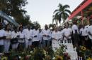 Haiti's President Martelly is flanked by Haiti's PM Paul and Martelly's wife Sophia, as they pay their respects to the victims of a carnival float that hit power lines, at the site of the accident in Port-au-Prince