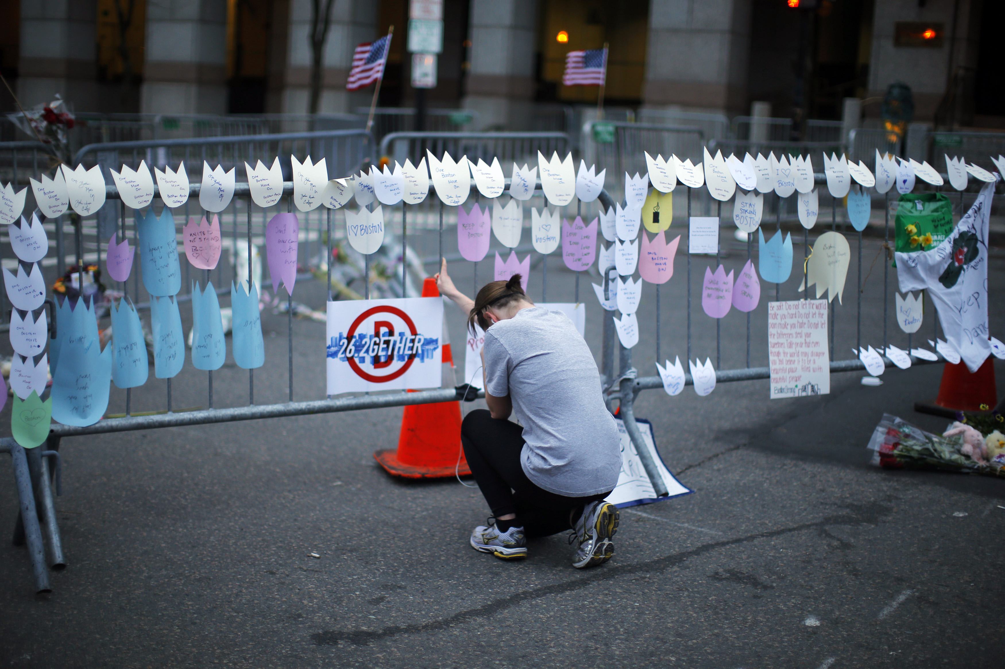 A woman kneels and cries in front of a memorial to the Boston Marathon bombings victims, at the barricades surrounding the scene in Boston, Massachusetts in this April 18, 2013 file photo. (Brian Snyder/REUTERS)