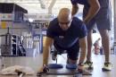 In this undated photo made from video and provided by Athletes Performance, U.S. Air Force, Chief Master Sgt. Damian Orslene works out in Gulf Breeze, Fla. At a Florida rehab center connected to one of the world's top sports surgeons, wounded military members like Orslene are recovering from injuries alongside professional athletes through a nonprofit program. Since 2010, more than 300 injured soldiers, sailors and Marines have worked on recovering from serious injuries with the help of physical therapists, trainers and nutritionists at Athletes Performance through the nonprofit Eagle Fund. (AP Photo/Athletes Performance)