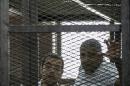 Al-Jazeera news channel's journalists Egyptian-Canadian Mohamed Fahmy (R) and Egyptian Baher Mohamed (L) listening to a verdict inside the defendants cage