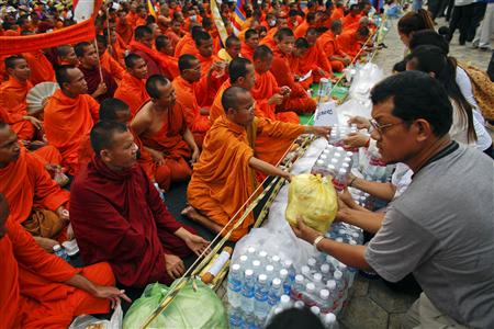 Supporters of Cambodia National Rescue Party (CNRP) offer food to Buddhist monks during the last day of protest at Freedom Park in Phnom Penh September 17, 2013. REUTERS/Athit Perawongmetha