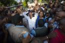 Haiti's former President Jean Bertrand Aristide, center, waves to the crowd after he urged supporters to vote for presidential candidate Maryse Narcisse, center right, of the Fanmi Lavalas political party, in Port-au-Prince, Haiti, Wednesday Sept. 30, 2015. Aristide's public endorsement could be a boon for Narcisse, who is polling well below front-runner Jude Celestin. During the last election cycle about five years ago, the party was barred from the ballot. (AP Photo/Dieu Nalio Chery)