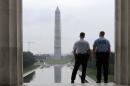 With the Washington Monument in the distance, Park Service police officers stand on duty at the Lincoln Memorial in Washington, Thursday, Oct. 17, 2013. Barriers went down at National Park Service sites and thousands of furloughed federal workers began returning to work throughout the country Thursday after 16 days off the job because of the partial government shutdown.(AP Photo/Susan Walsh)
