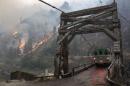 The TePee wildfire is seen burning at the Manning Bridge as it crosses the Salmon River near Riggins, Idaho
