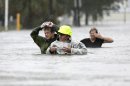 Chuck Cropp, center, his son Piers, left, and wife Liz, right, wade through floodwaters from Hurricane Isaac Wednesday, Aug. 29, 2012, in New Orleans. As Isaac made landfall, it was expected to dump as much as 20 inches of rain in several parts of Louisiana. (AP Photo/David J. Phillip)