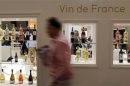 A visitor walks past wine bottles displayed at Vinexpo wine fair in Bordeaux