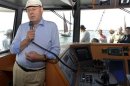 Steinbrueck SPD candidate in general elections talks to tourists with microphone during harbour trip on boat in Warnemuende