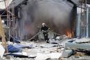 Firefighter works to extinguish a fire at a local market which was recently damaged by shelling in Donetsk