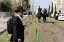 An ultra-Orthodox Jewish onlooker stands near Israeli mounted police near the scene where Israeli police said two Palestinian assailants carried out a drive-by shooting on a commuter bus before being shot dead by police outside Jerusalem's Old City