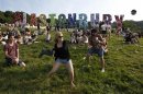 Festival goers play rounders with a wellington boot and a beer can on the first day of Glastonbury music festival at Worthy Farm in Somerset