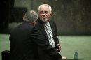 Iran's Foreign Minister Mohammad Javad Zarif speaks with an MP during a parliament session in Tehran on August 15, 2013