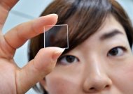 A woman holds up Japanese electronics giant Hitachi's new quartz glass plate technology, which can be used to store data indefinitely, in Tokyo on September 24. The company on Monday unveiled a method of storing digital information on slivers of quartz glass that can endure extreme temperatures and hostile conditions without degrading, almost forever