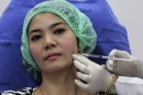 In this Oct. 17, 2012 photo, a 32-year-old Thai woman, Nisakron Boonpun gets a Botox injection at Bangkok's Yanhee Hospital, which houses one of the country’s best-known and largest beauty clinics. Bangkok has more than 500 licensed beauty clinics that cater to the wealthy but is also full of illegal, back-alley beauticians who are attracting young and working-class customers with rock-bottom prices. The recent case of a 33-year-old aspiring model who died from a botched collagen injection has drawn attention to the dark side of a booming beauty industry in Thailand. (AP Photo/Sakchai Lalit)