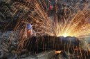 A labourer cuts scrap steel at a factory of Dongbei Special Steel Group Co., Ltd., in Dalian, Liaoning province July 24, 2013.REUTERS/China Daily