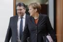 German Chancellor Angela Merkel, right, and German Economy and Energy Minister Sigmar Gabriel, left, arrive for the weekly cabinet meeting at the chancellery in Berlin, Germany, Wednesday, Dec. 17, 2014. (AP Photo/Michael Sohn)