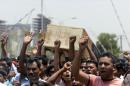 Garment workers and activists carry a mock coffin during a protest in front of the Bangladesh Garment Manufactures and Exporters Association (BGMEA) office in Dhaka on April 23, 2014